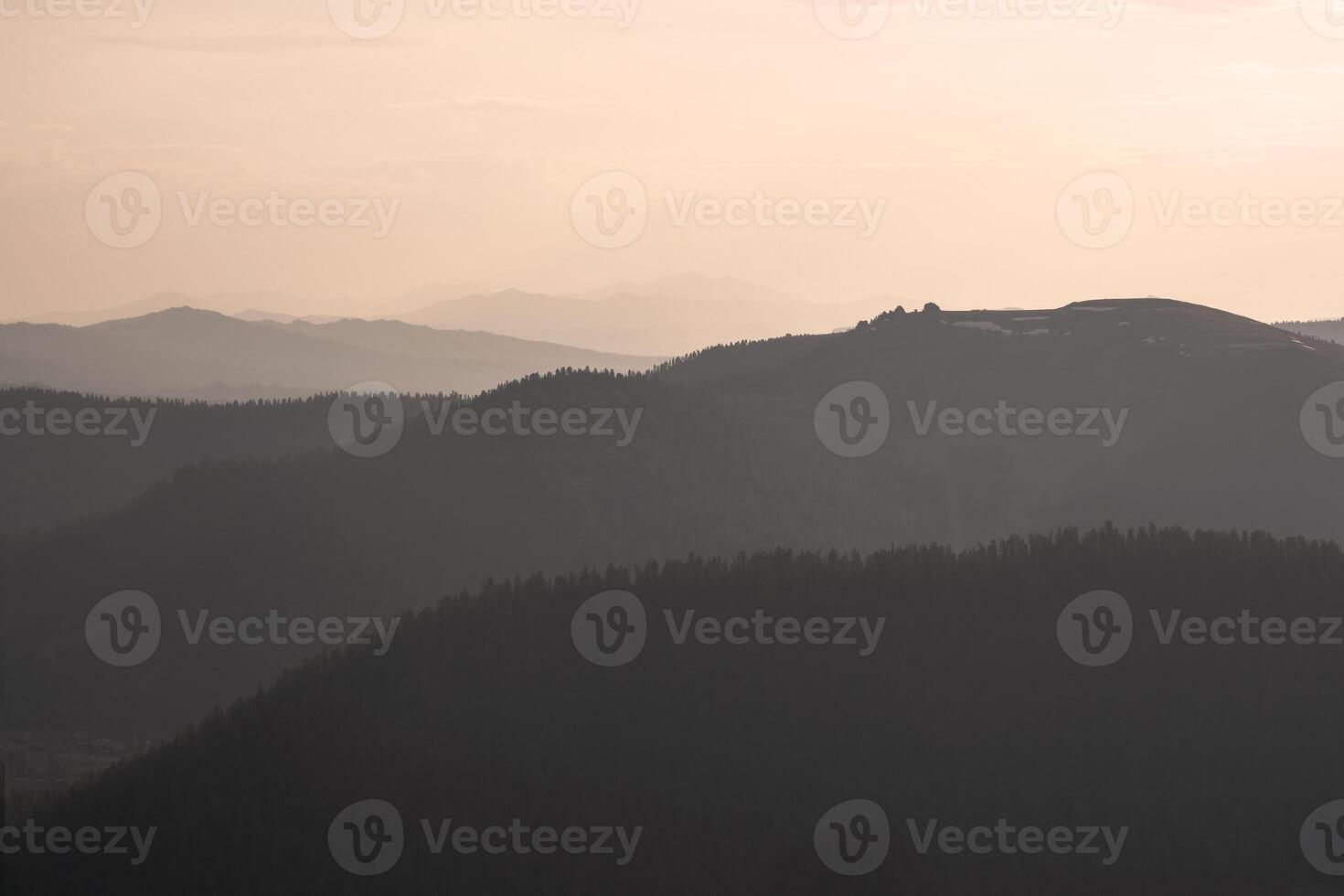 Golden sunset in mountain landscape. Layers of mountains background. Silhouette of the evening mountains at sunset. photo