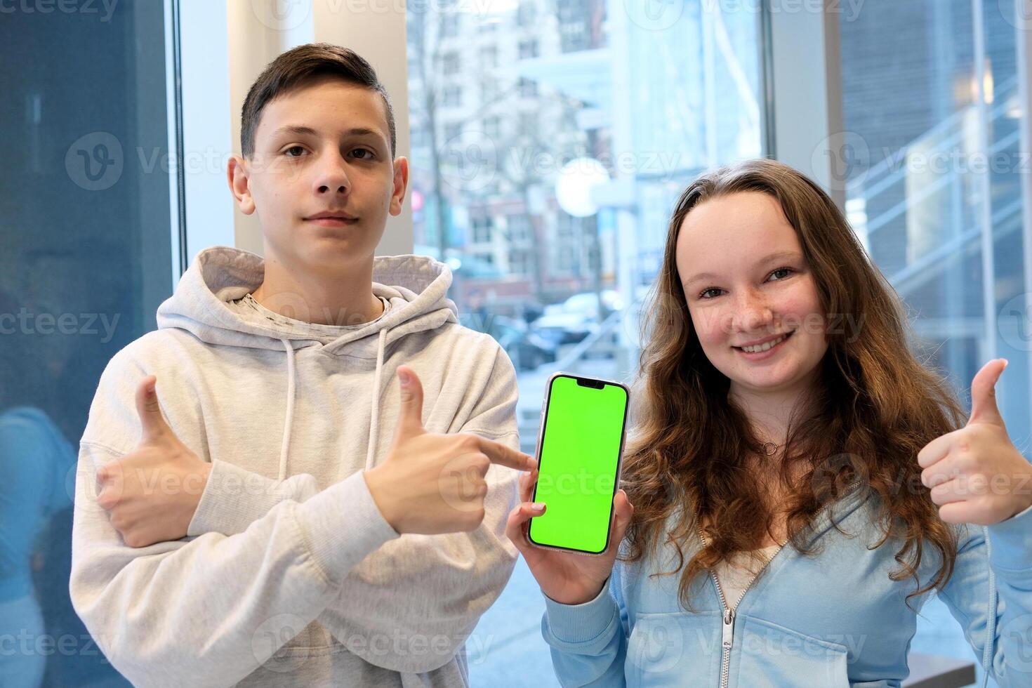 Group of cheerful students taking a selfie with a cellphone while sitting outdoors with a laptop, capturing a fun moment together, showcasing friendship, technology, and student life on campus. High photo