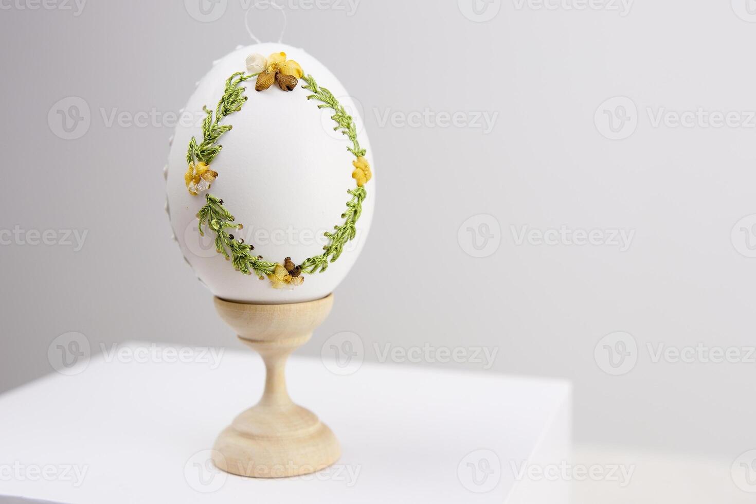 White Easter eggs made with decoupage technique with floral motifs and a flowering branch on a black rustic background. photo