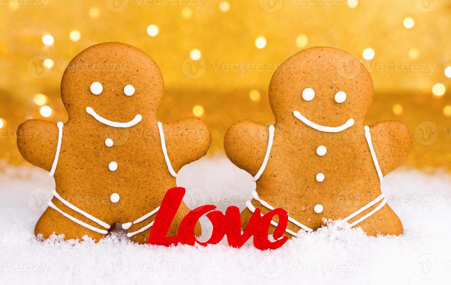 Couple gingerbread men and the word LOVE on a snowy background. Valentine's Day. Close-up. photo