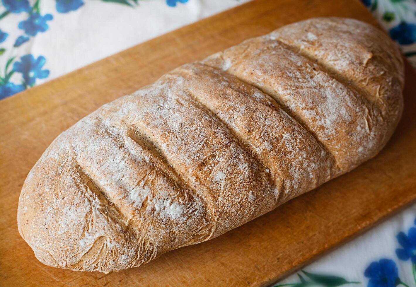 Freshly baked homemade bread on wooden cutting board. photo