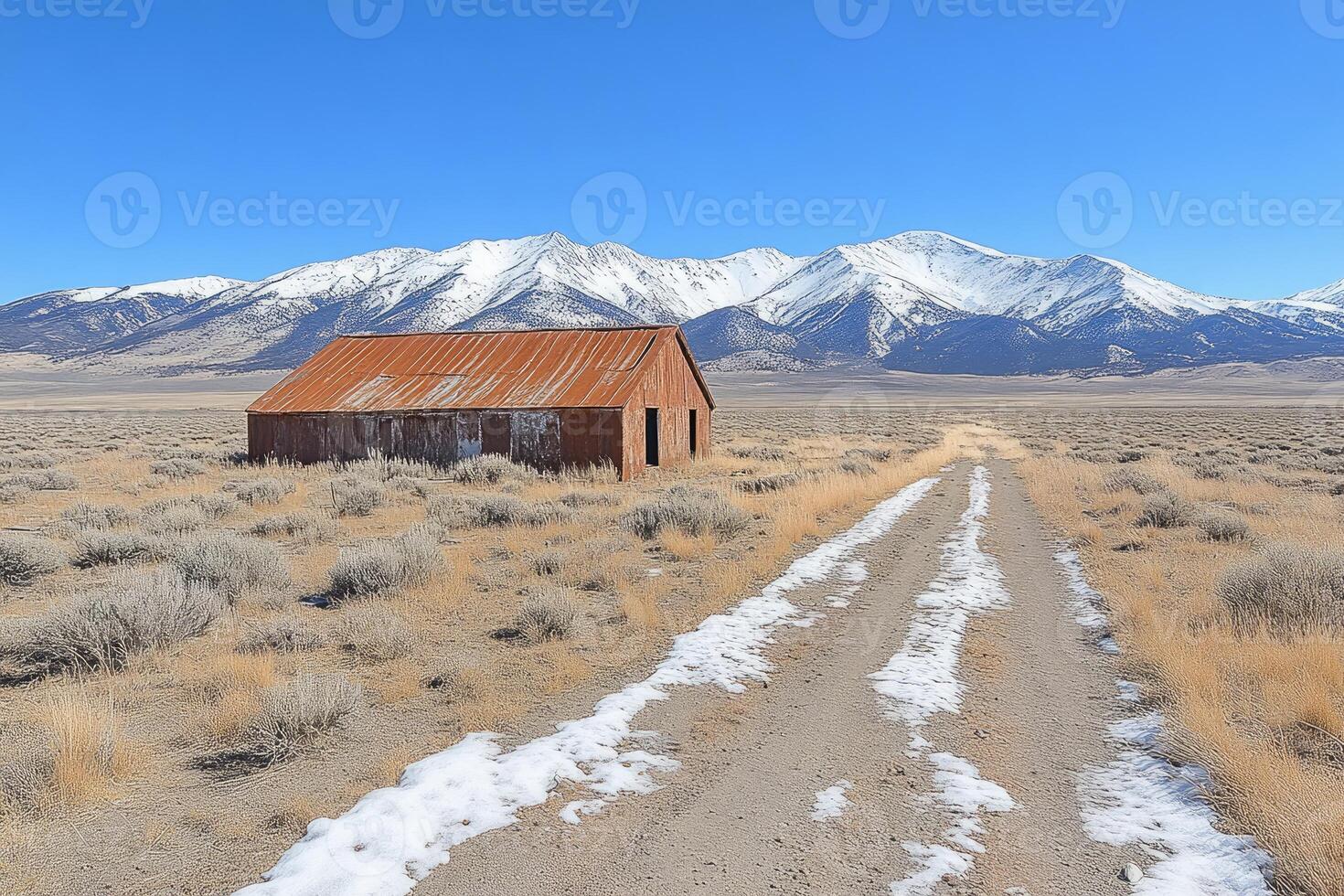 Rusty Barn Stands Alone Near Snowy Mountains photo