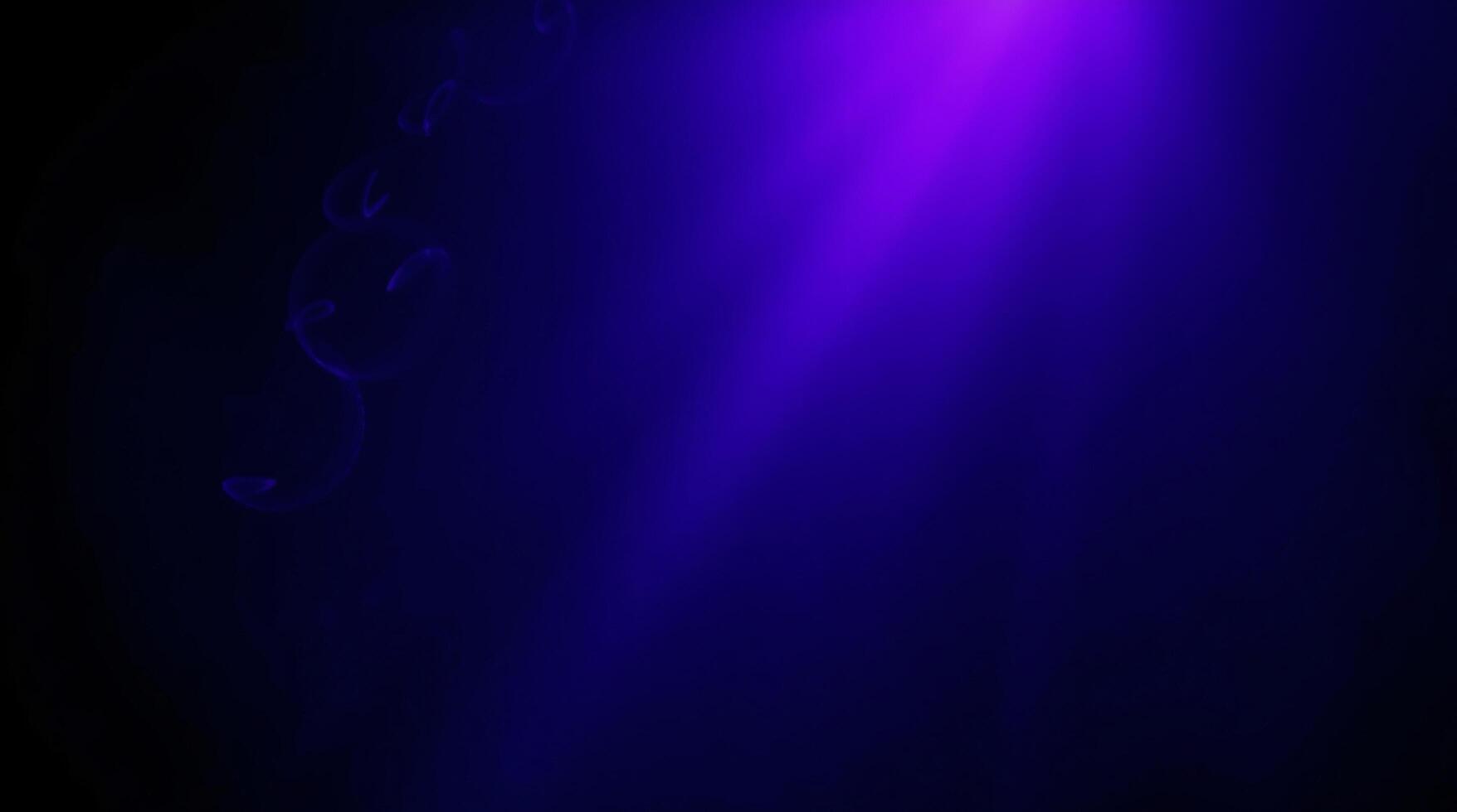 A purple light is shining on a black background photo