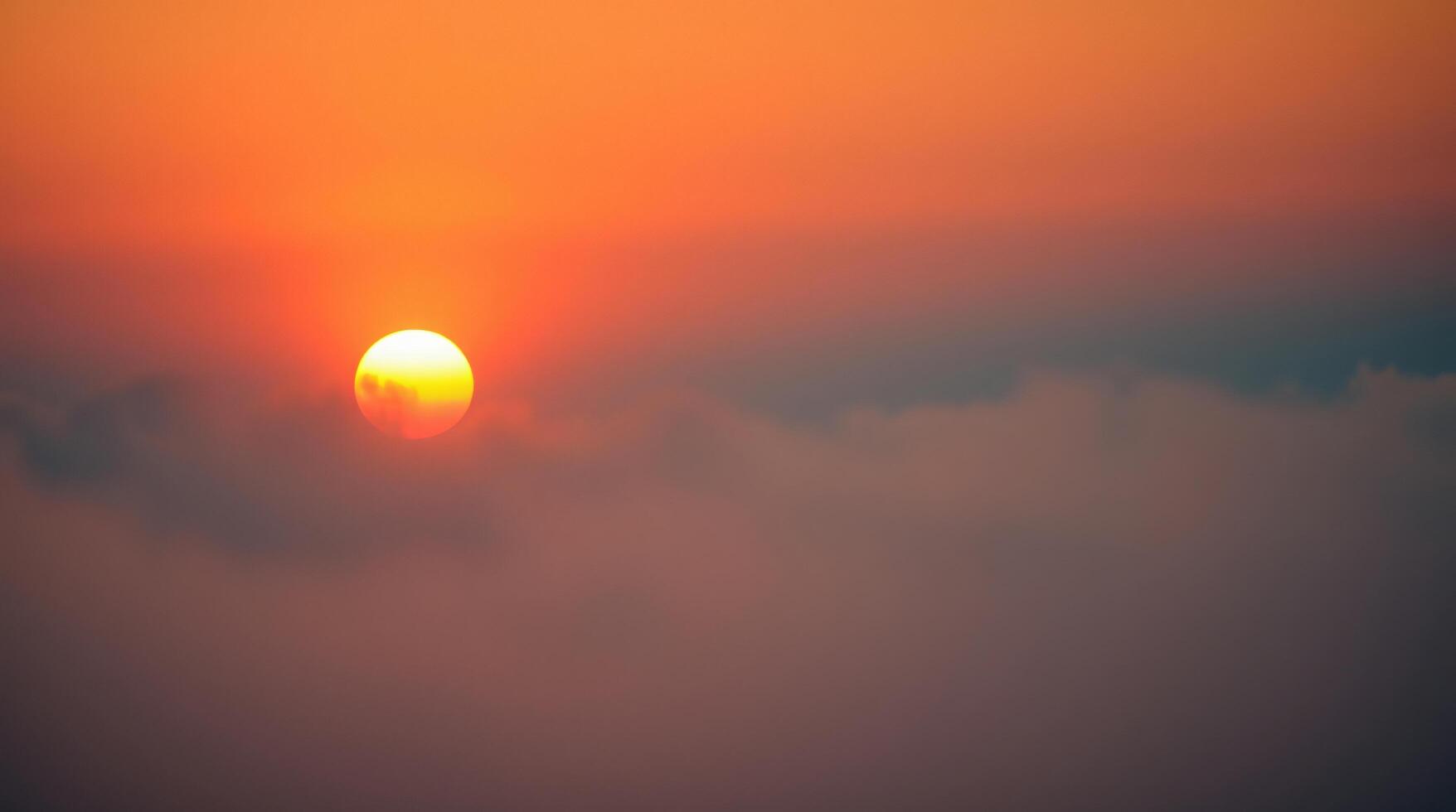 The sun is setting over the clouds photo