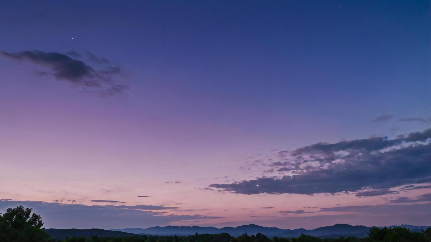 A purple sky with clouds and mountains in the background photo