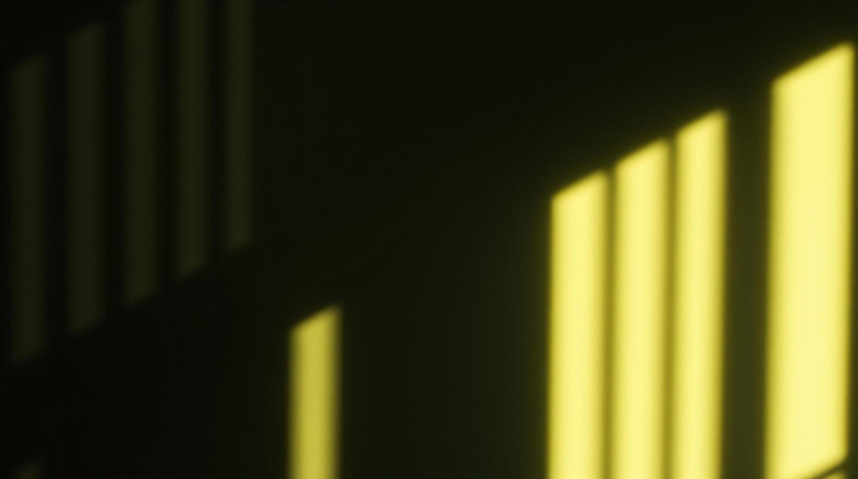 A yellow light shines through the bars of a window photo