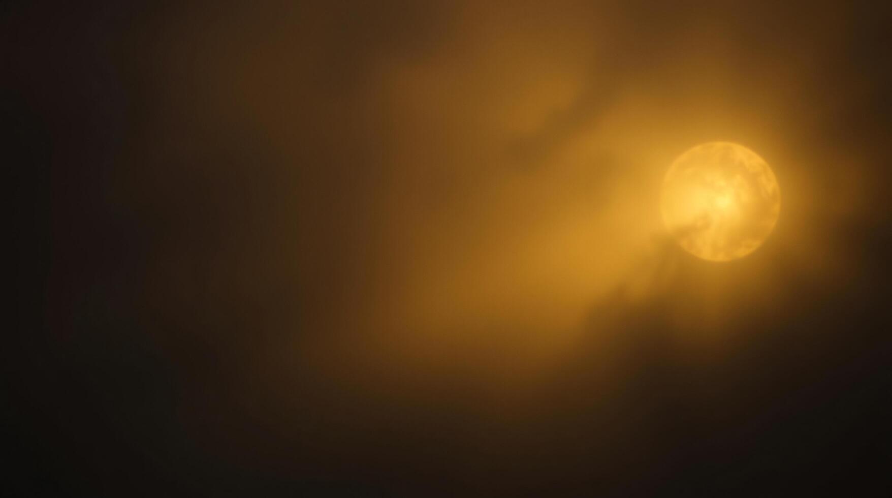A yellow sun is seen in the dark sky photo