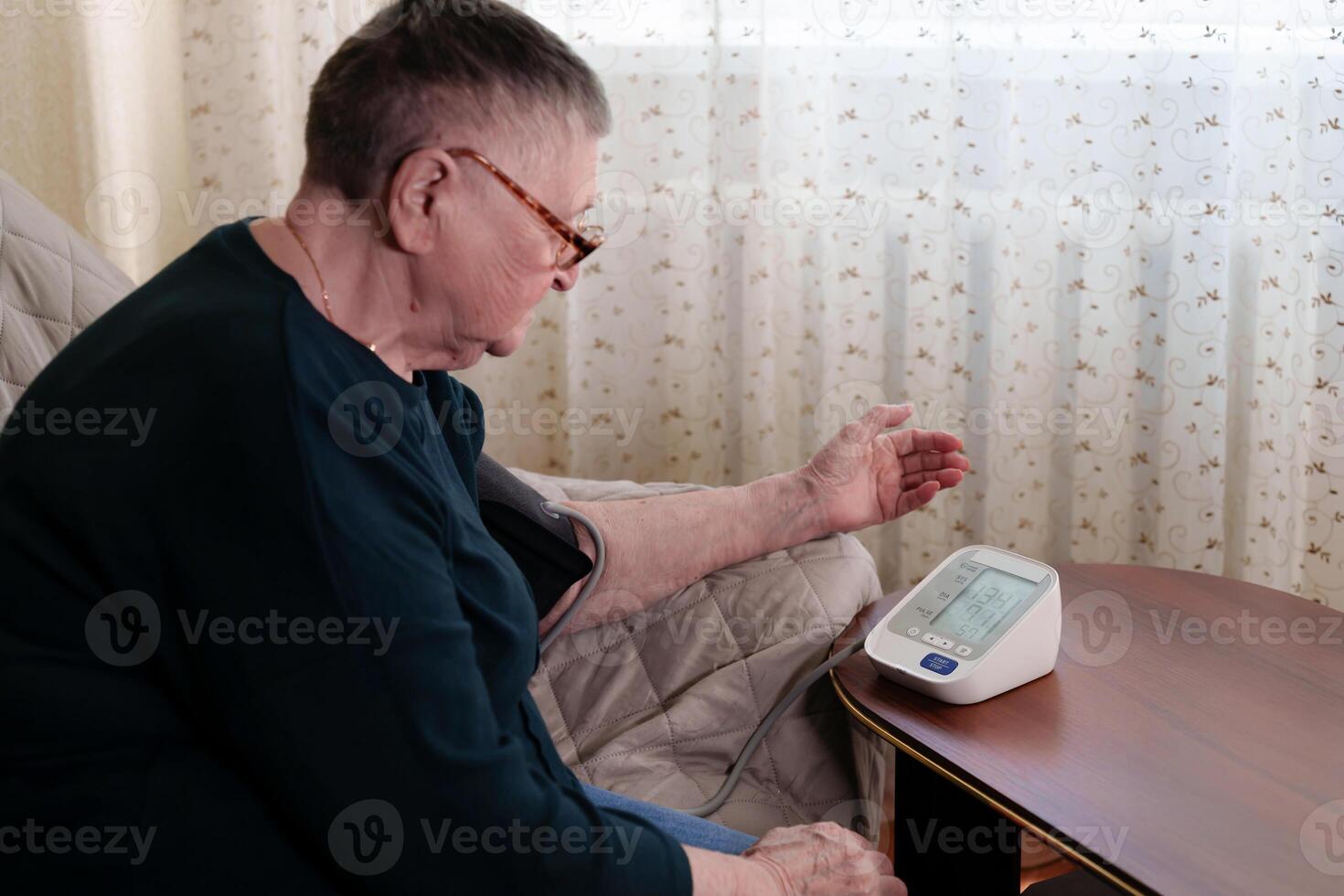 Woman alarmed by dangerously high blood pressure reading, underscoring urgent need for medical intervention and treatment to mitigate cardiovascular health risks photo