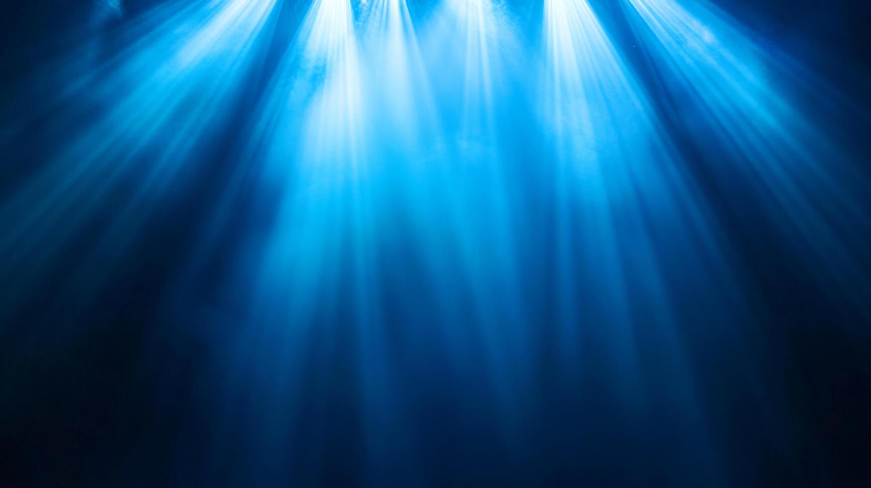 Blue beams of light shine through the misty darkness photo
