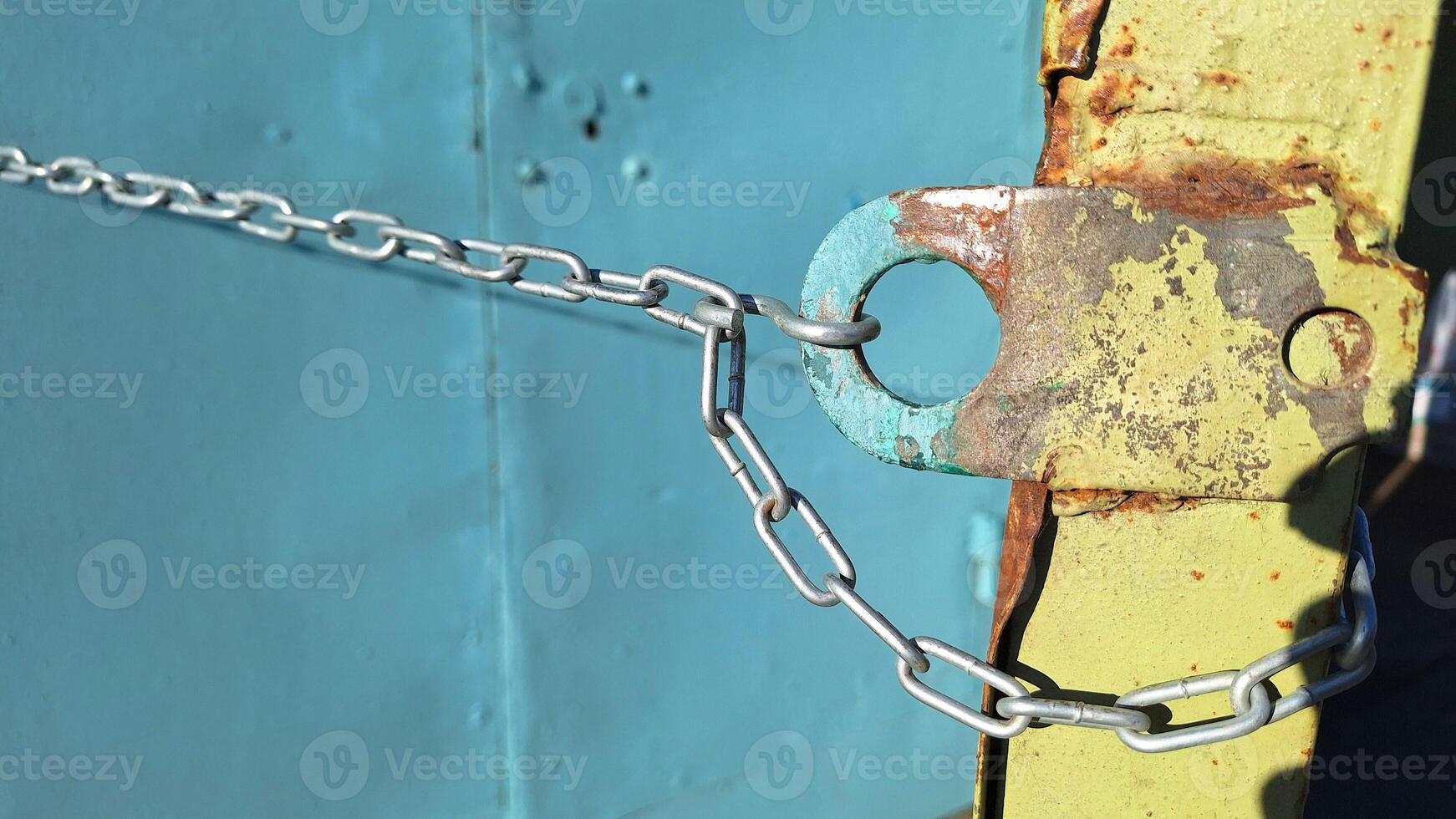 Rusty metal lock with chain on weathered blue background photo