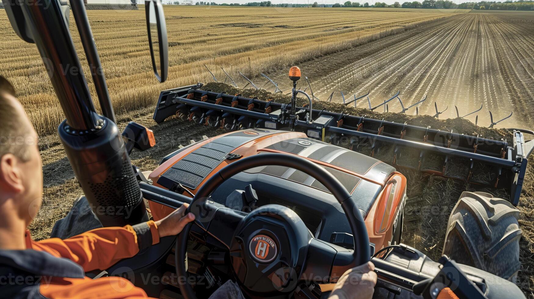 Farmer operating modern tractor in vast harvested field photo