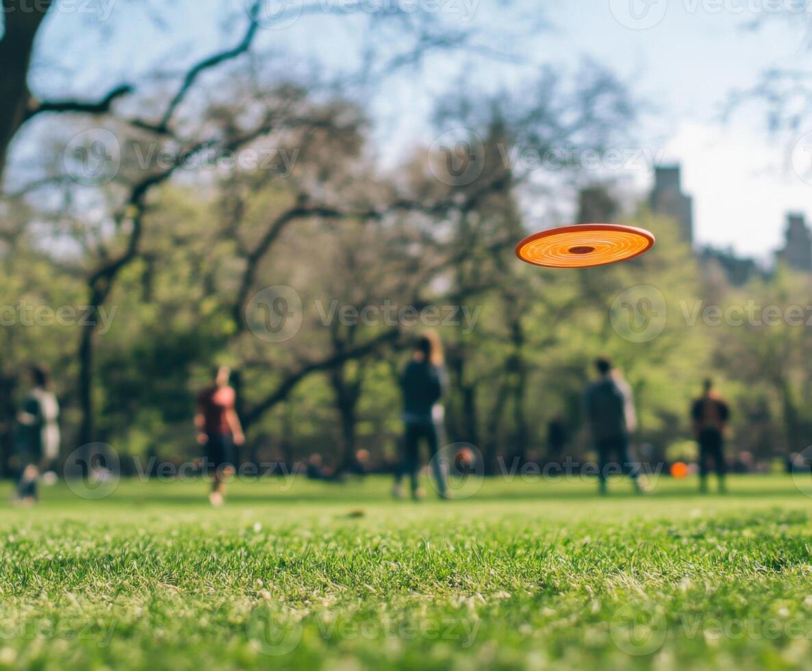 Frisbee flying over a green field with people enjoying a sunny day in the park photo