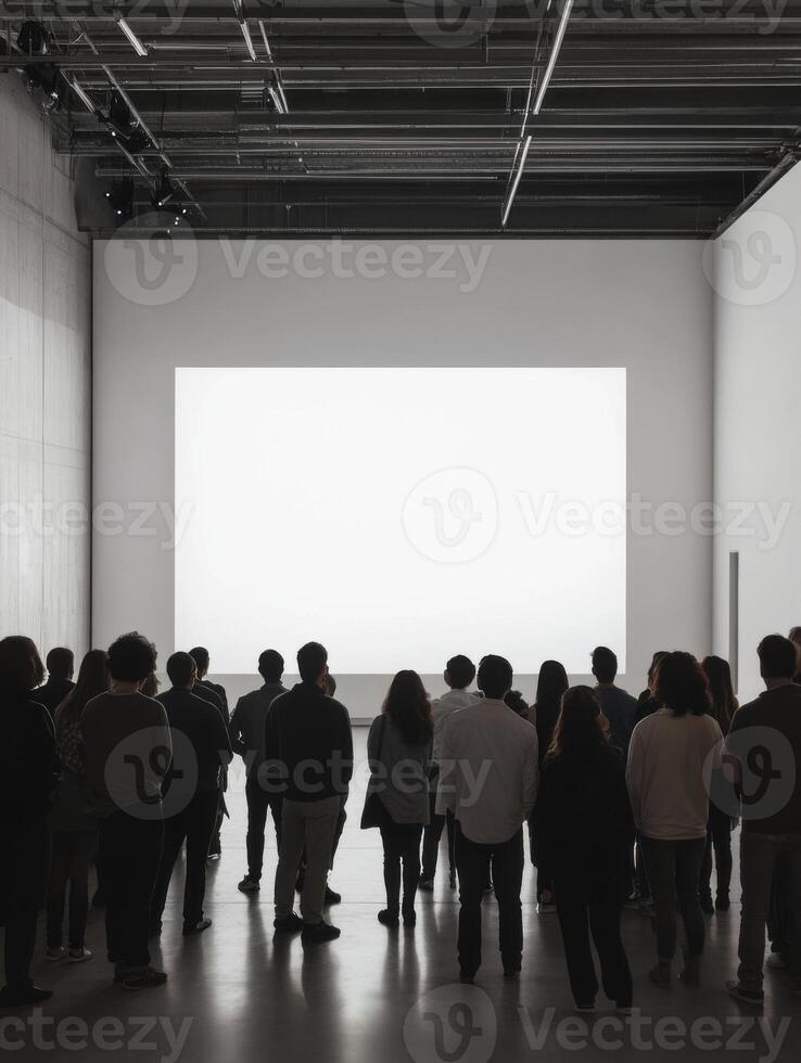 Audience observes presentation in modern gallery space during evening art event showcasing contemporary works photo