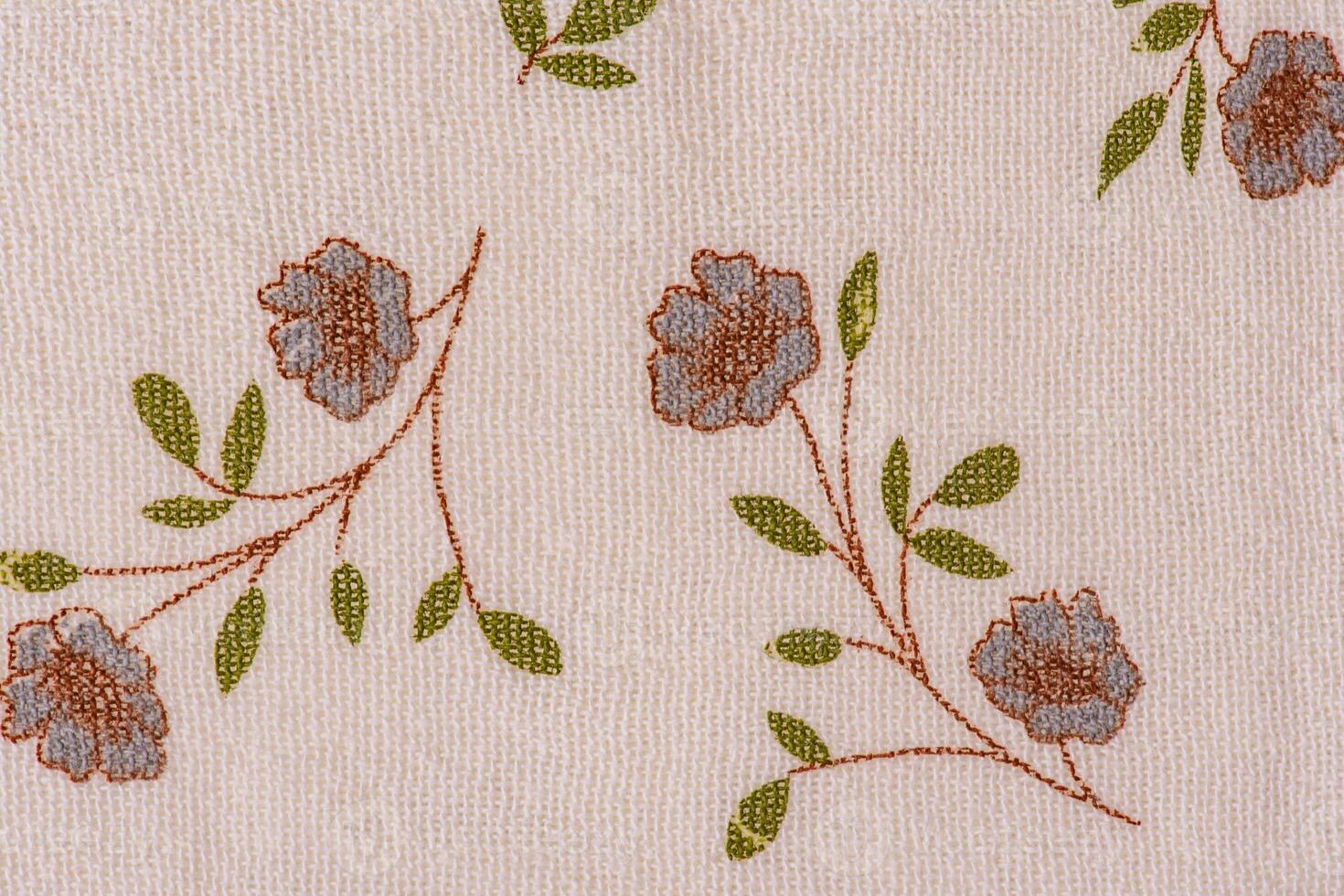 Light beige fabric with gray flowers with brown and green petals. photo