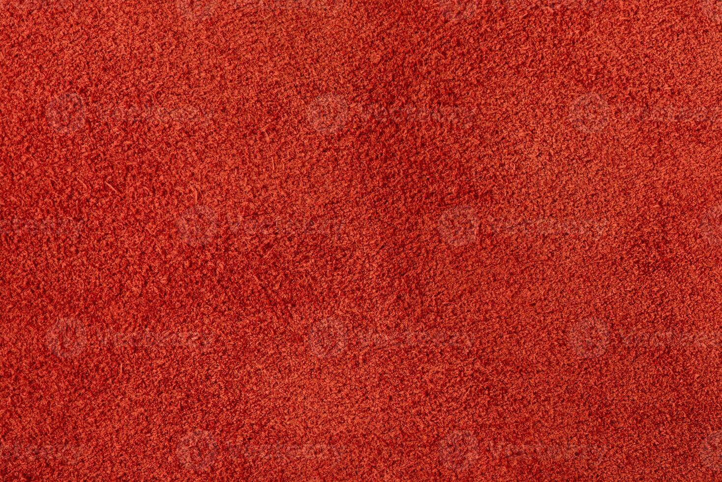 Suede in a warm shade of red as a background. photo