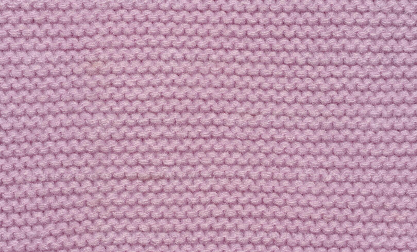 Knitted fabric made of pink wool threads, pigtail pattern, full frame. photo