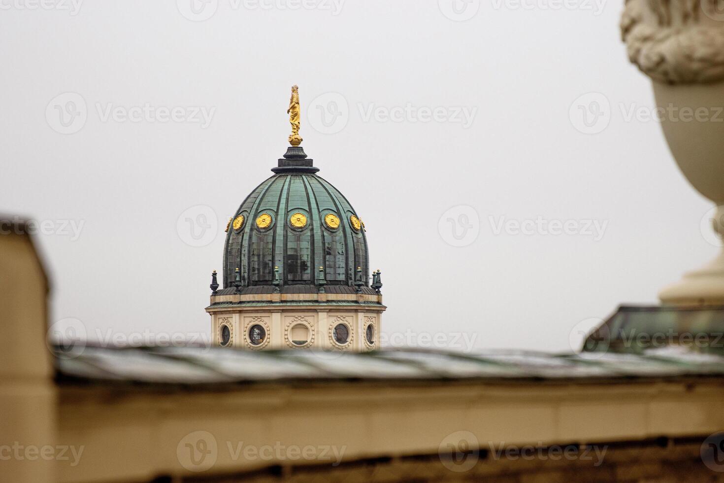 Closeup of the New German Cathedral Dome. Iconic Berlin landmark with golden statue details, seen from the French Church rooftop terrace against a soft skyline. Minimalist photo. Copy space 5 photo