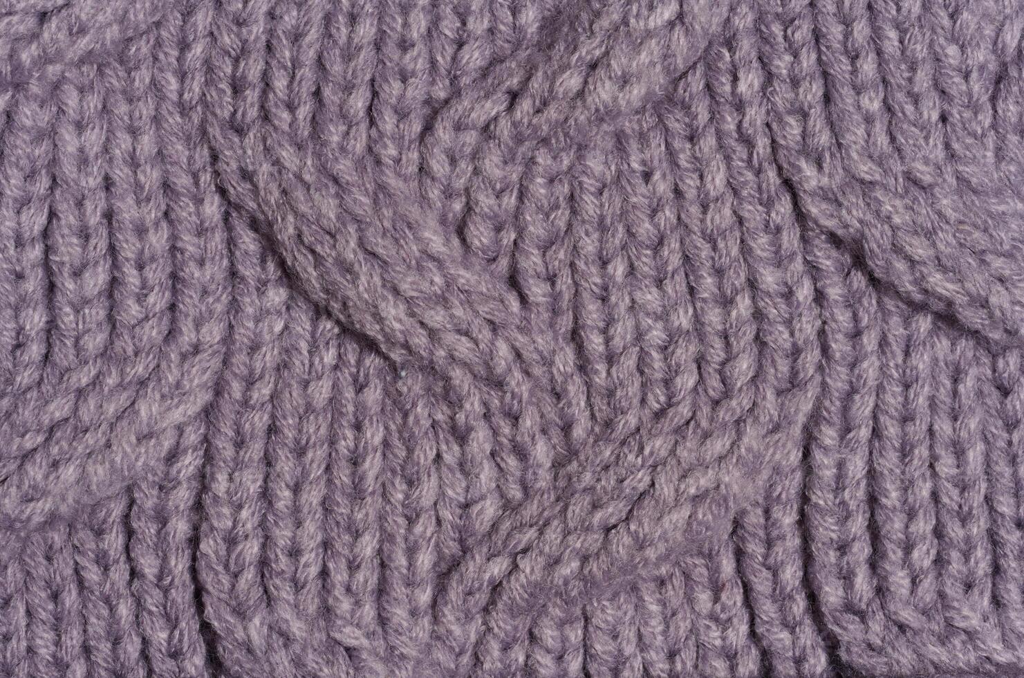 Knitted fabric made of purple wool threads, pigtail pattern, full frame. photo