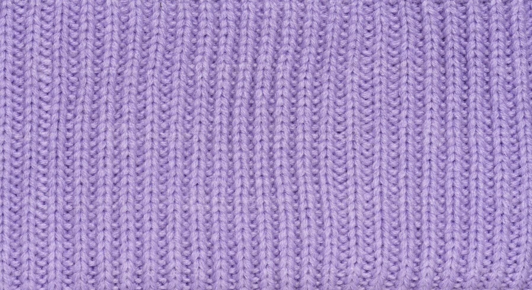 Knitted fabric made of purple wool threads, pigtail pattern photo