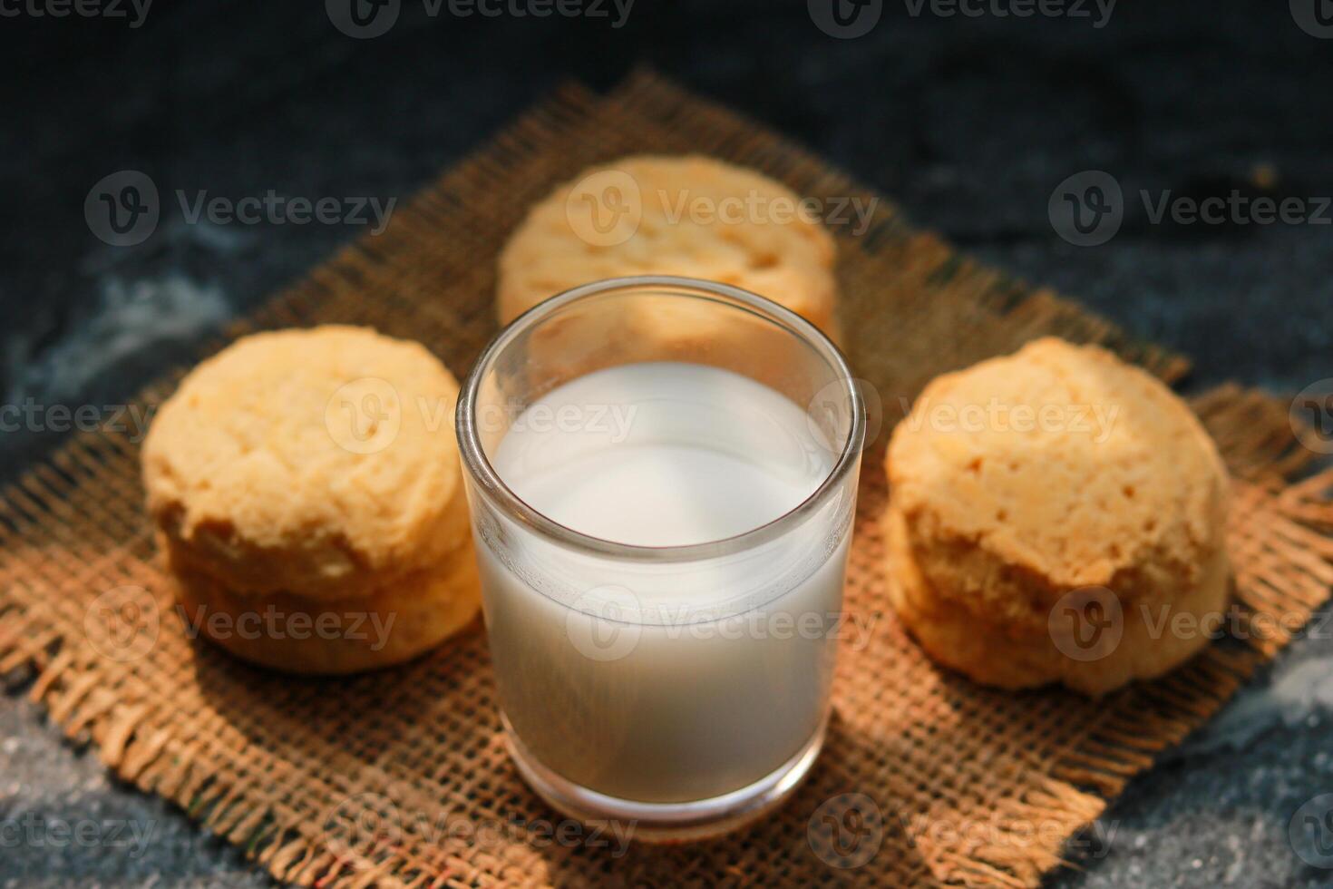 Milk in glass and cookies on the table, closeup of photo front view