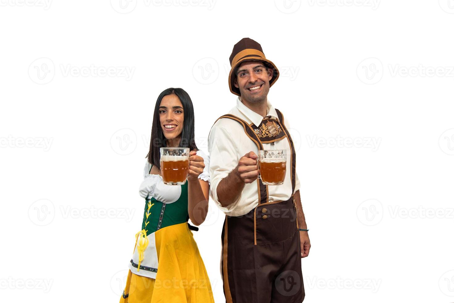 Smiling young Bavarian couple in traditional clothing holding beer glasses at Oktoberfest photo