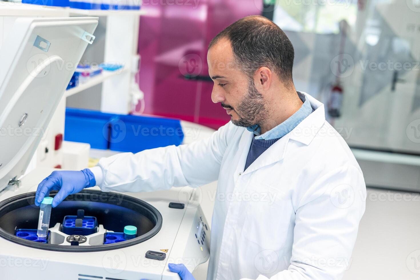 Scientist placing test tube in modern laboratory centrifuge photo