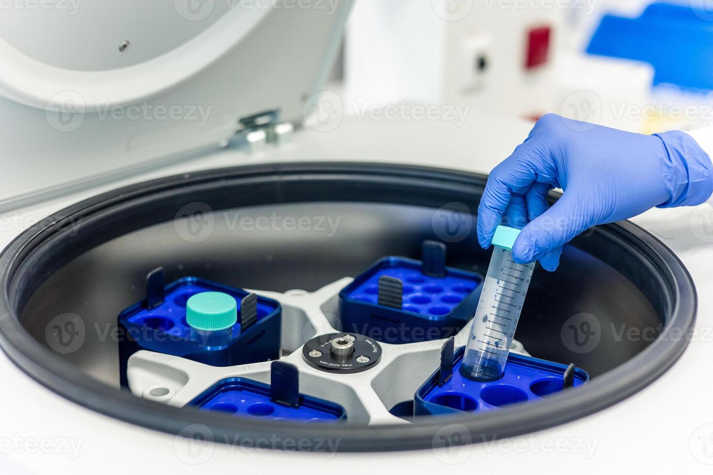 Scientist placing test tube in laboratory centrifuge for medical research photo