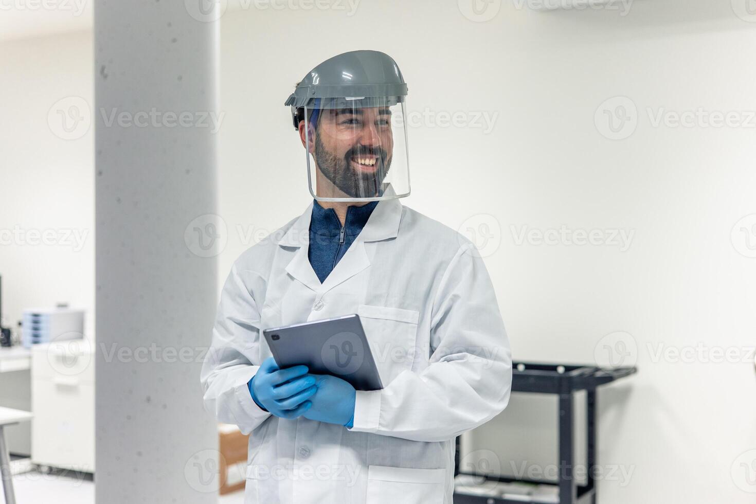 Scientist wearing face shield and holding tablet in laboratory photo