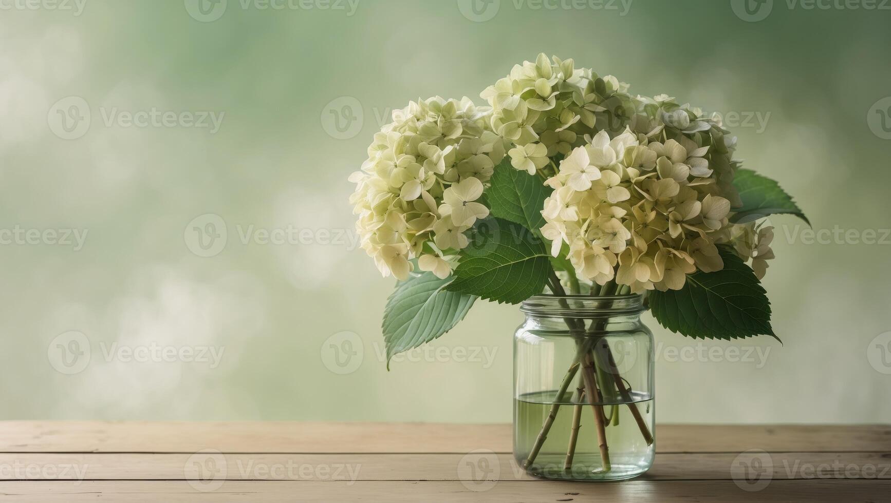 Bouquet of hydrangeas flowers in a glass jar on a wooden table with blurred green background photo