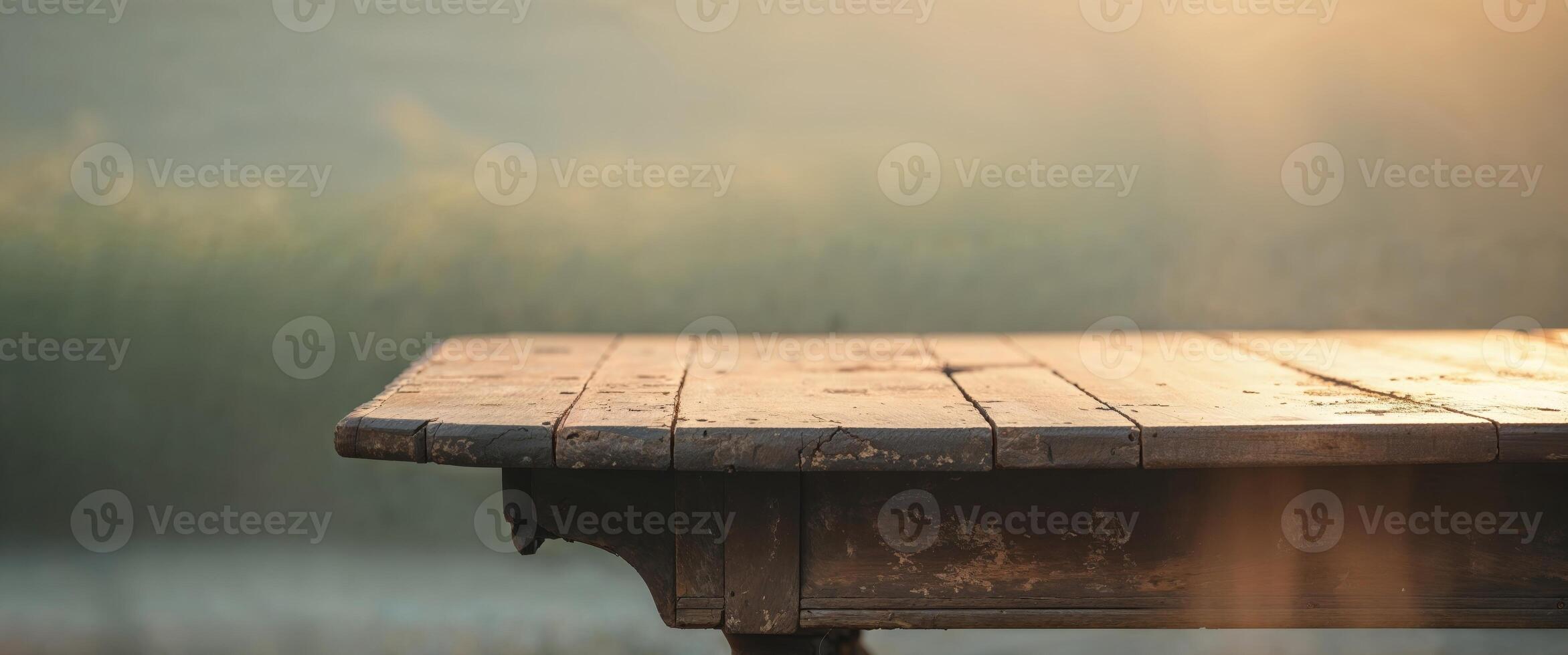 Soft sunlight casts a cozy glow on an old wooden table in a tranquil setting photo