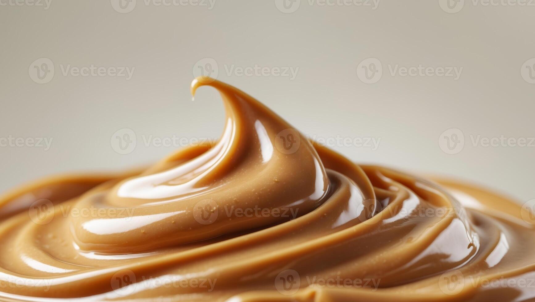 Close up of creamy smooth peanut butter texture with glossy sheen and rich golden brown color perfect for food and culinary backgrounds photo