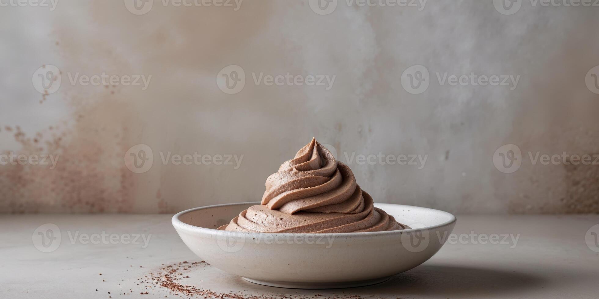 Creamy mocha mousse dessert swirled in bowl on textured gray background. photo