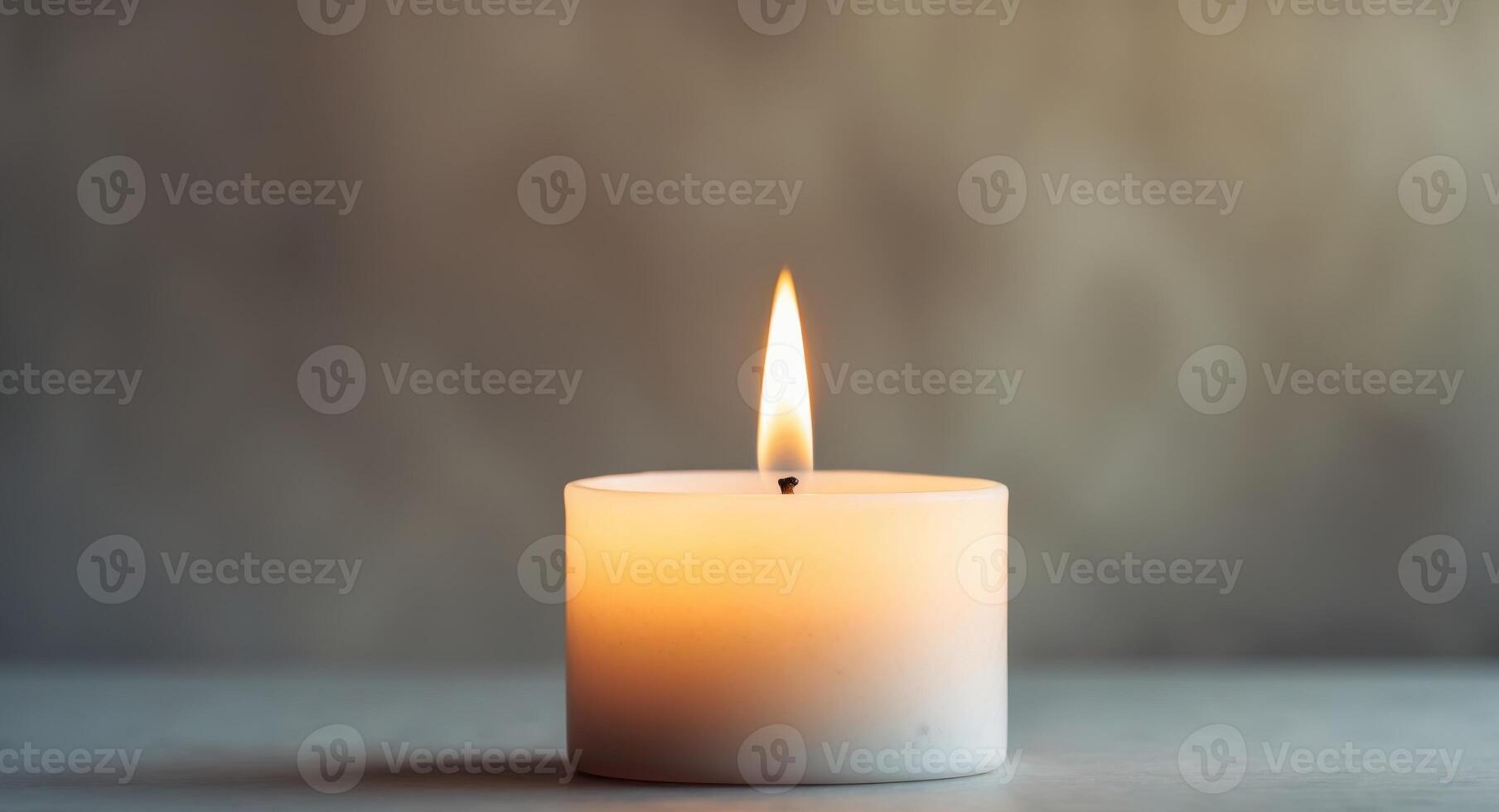 Single lit candle with a golden flame casting a warm glow in a serene setting. photo