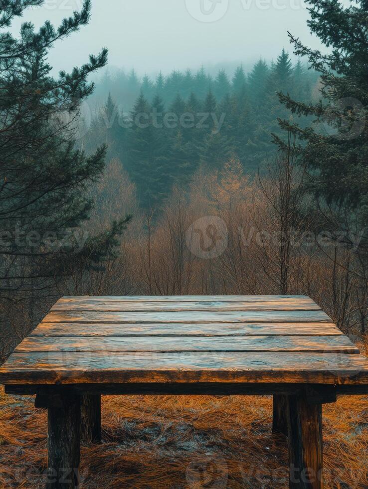 A wooden table in a misty forest, surrounded by trees and autumn foliage. photo