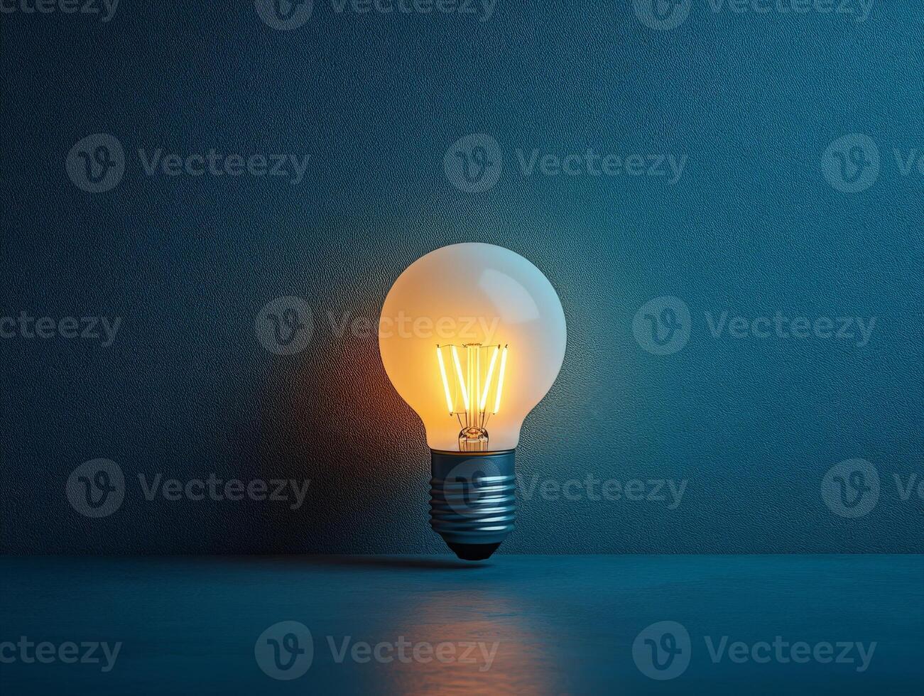 A glowing light bulb on a dark blue background, symbolizing ideas and innovation. photo