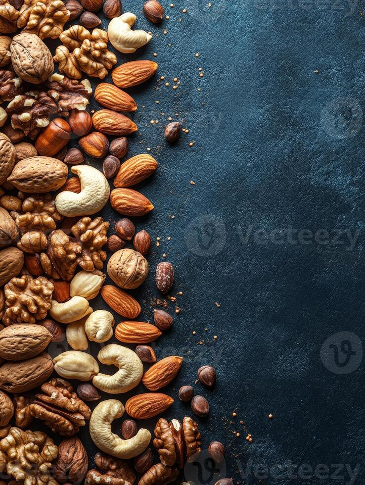 A variety of nuts and seeds arranged on a dark background for culinary use. photo
