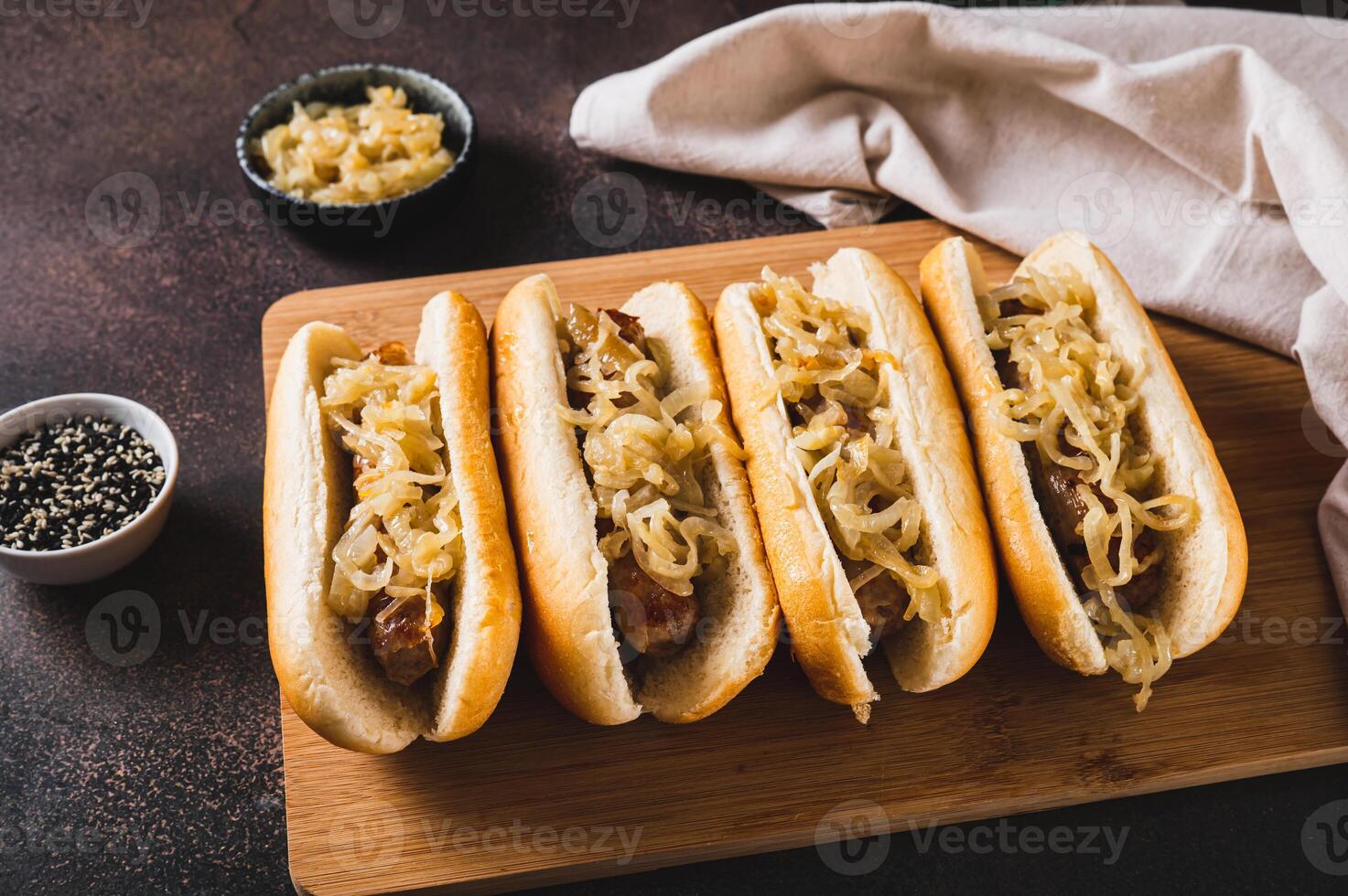 Delicious hot dogs with beef sausage and fried onions on a board photo