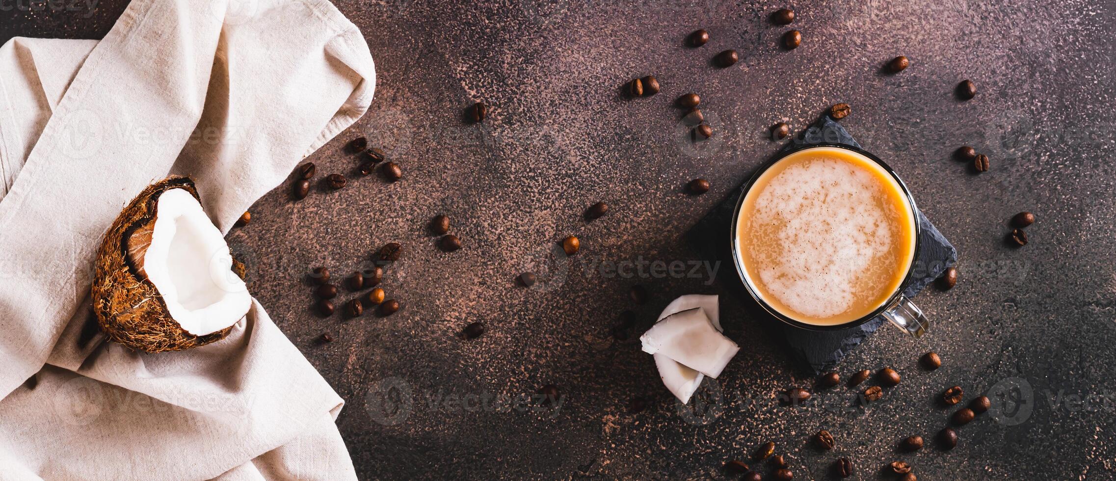Cup of iced coconut coffee, coconut pulp and coffee beans on table top view web banner photo
