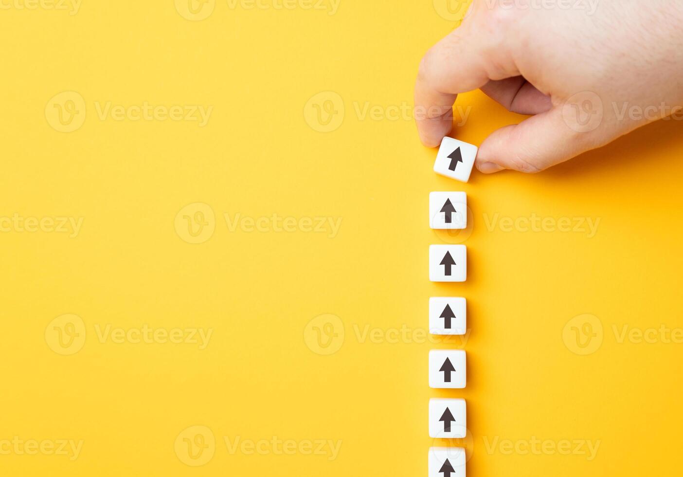 Hand making a row of arrows on a yellow background. Space for text. Paving the way, making plans. Next steps and vision. Course to go forward. photo