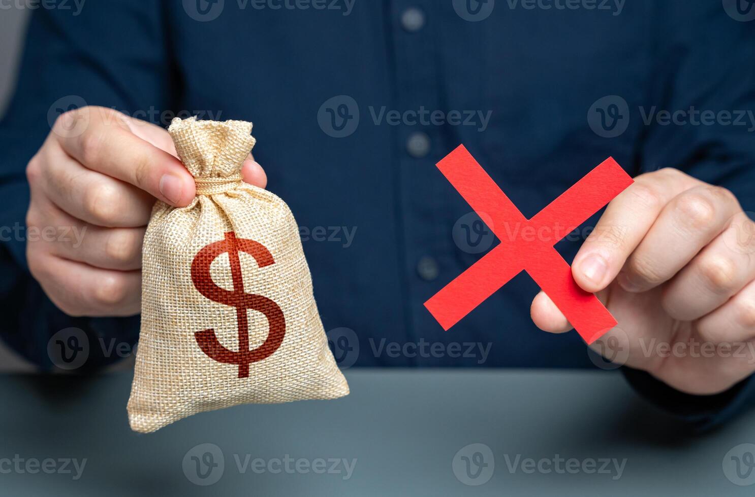 Man holding red cross and dollar money bag. Refusal to grant a loan. Failure to return the collateral. Refusal of sale and cooperation. Risk of confiscation of funds. photo