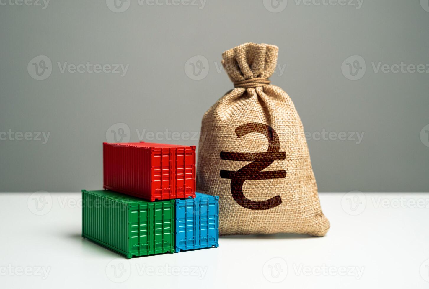 Stack of shipping containers and ukrainian hryvnia money bag. GDP and production. Import or export. Production of containers. Trade, economics and transport industry. Tariffs and tax collections. photo