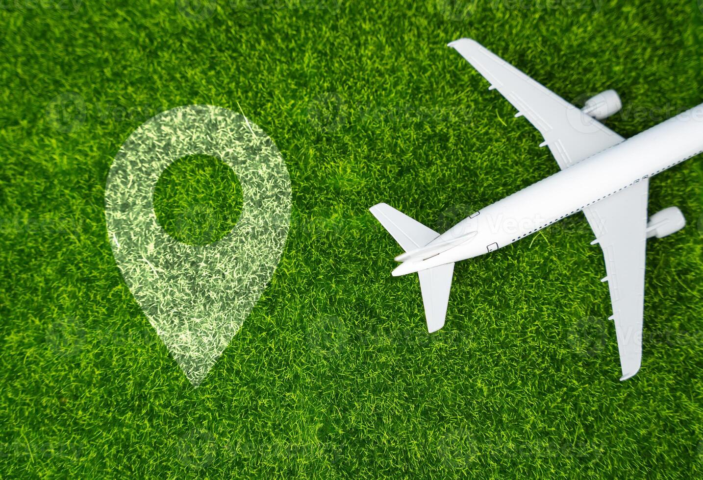 Airplane and geolocation sign on the grass. Travel and business trips. Transport system and infrastructure. Air communication. World flight routes. photo