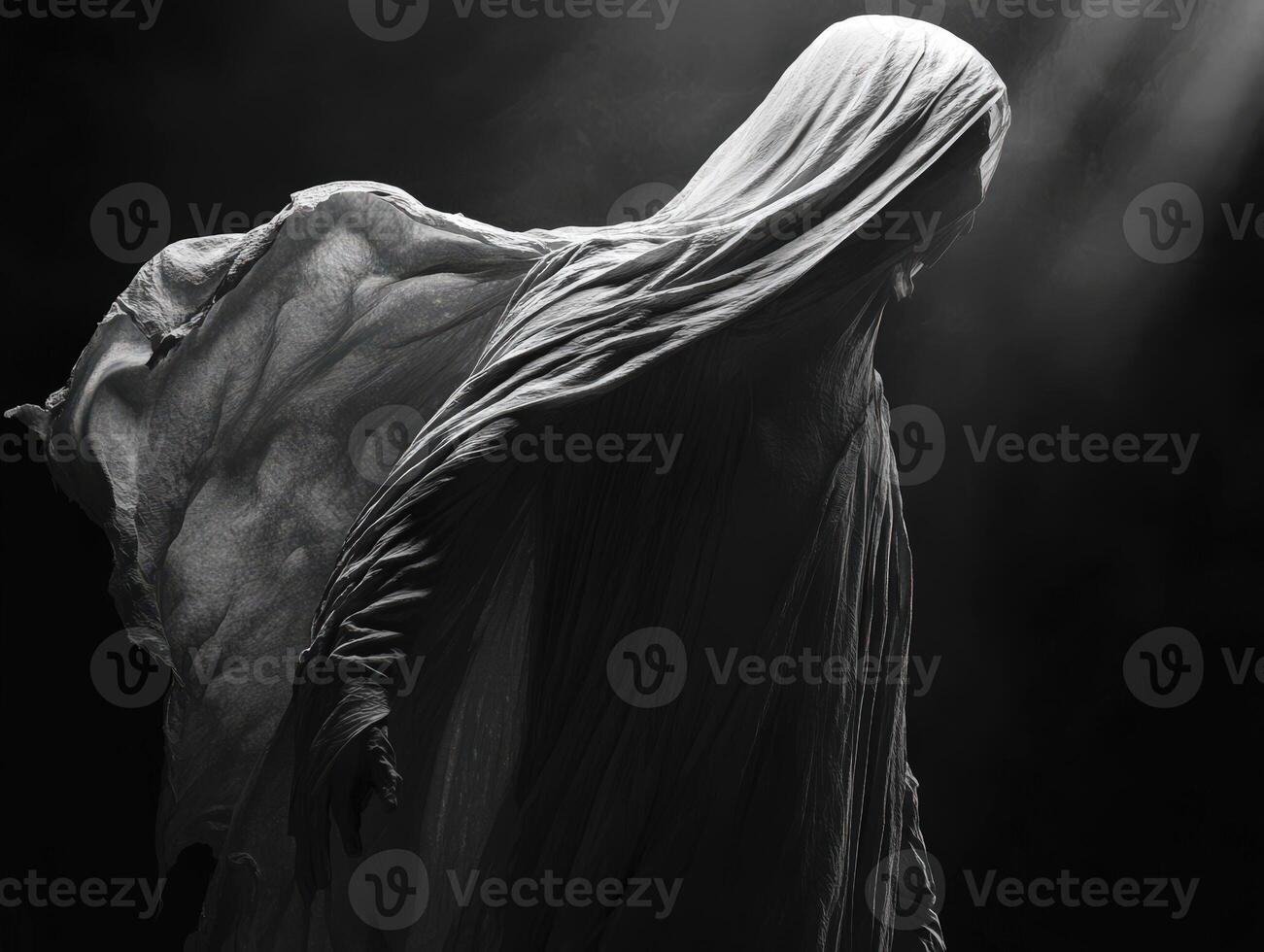 Ethereal figure cloaked in flowing fabric illuminated by soft light photo