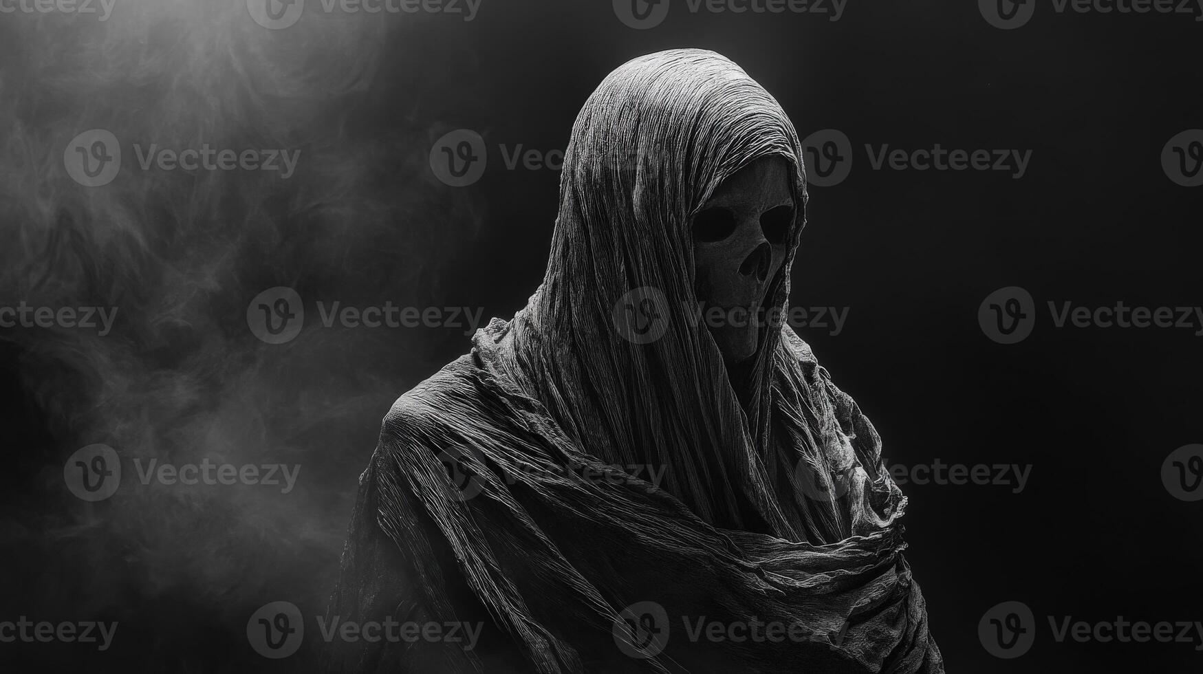 Mysterious figure in dark shroud with skull in smoky environment photo