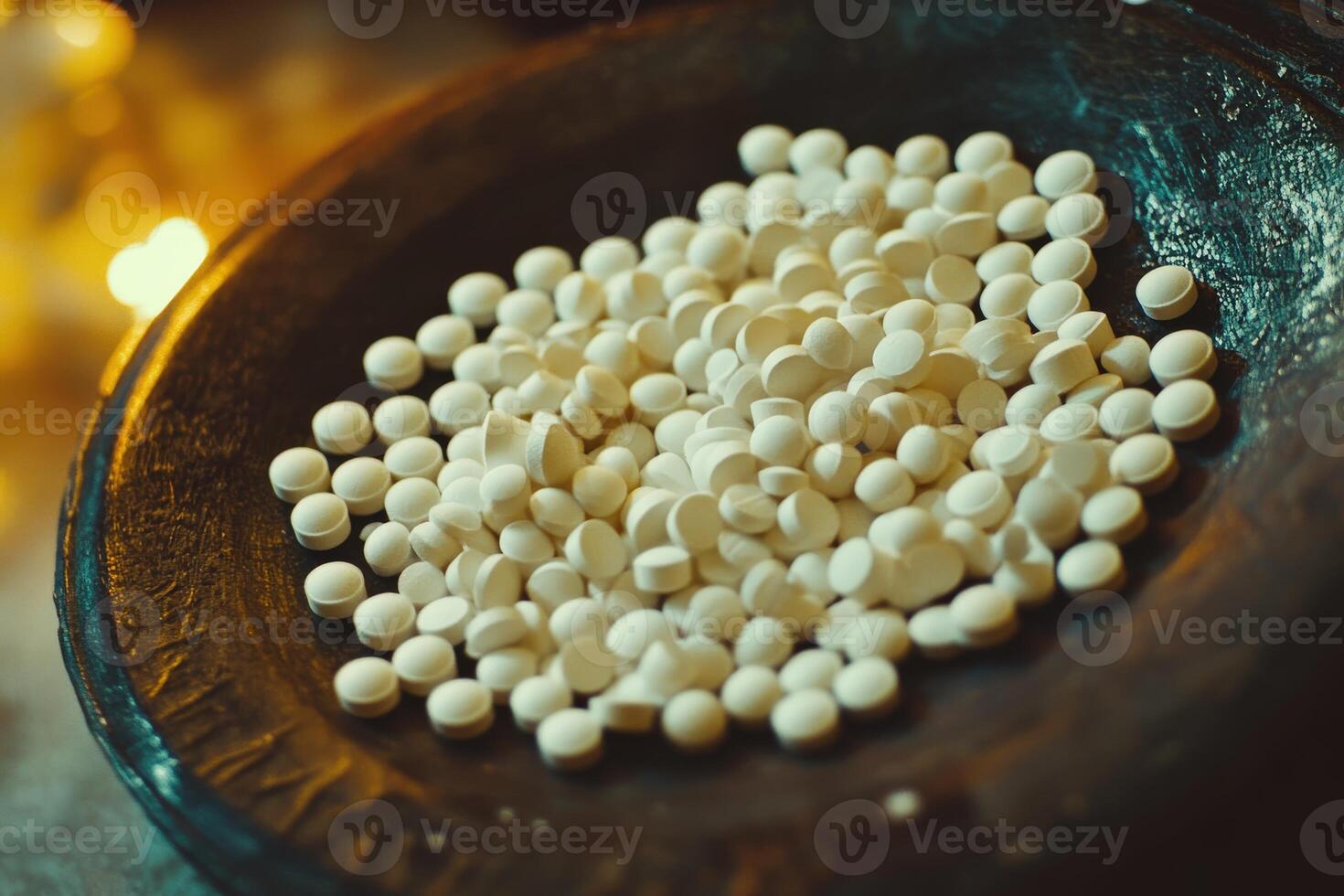 Multiple white tablets displayed on a dark plate near candlelight photo