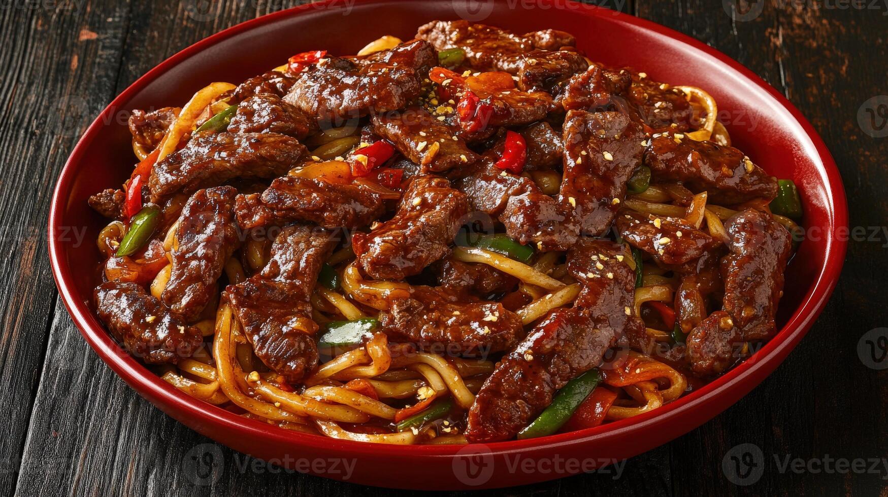 Chinese stir-fried beef with vegetables served in a red bowl photo