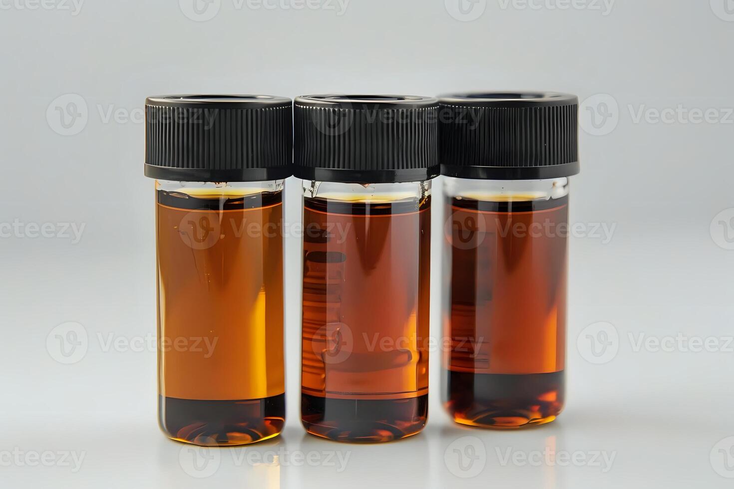 Amber Liquid Samples in Glass Vials. A Close-Up Examination of Three Containers Filled with a Translucent, Golden-Brown Substance, Showing Detailed Textures and Reflections on a Light Background. photo