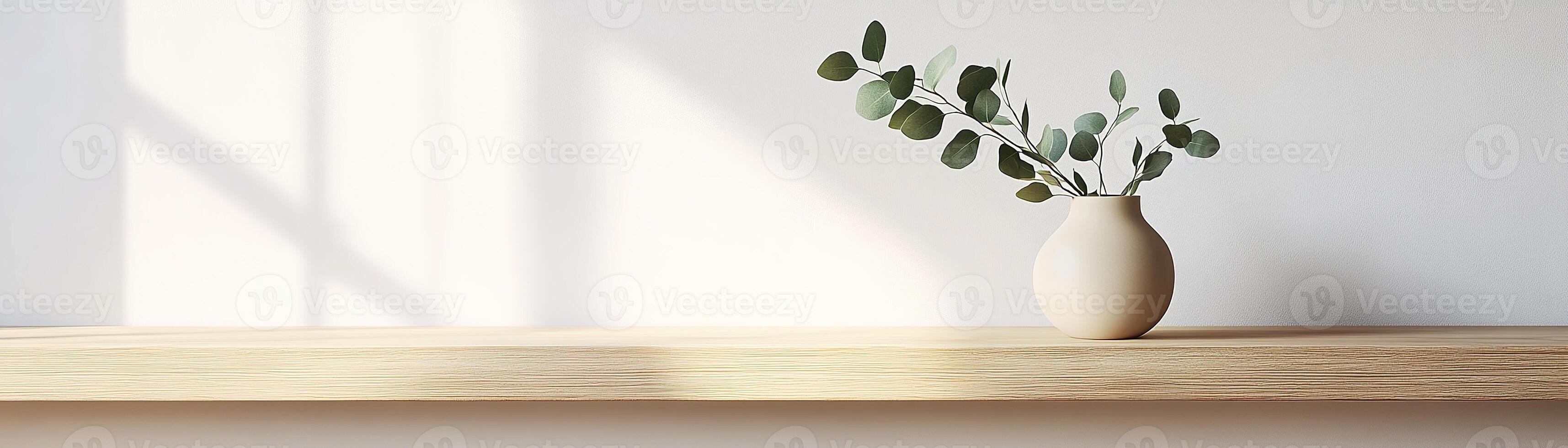 A light oak wooden shelf displays a soothing matte ceramic vase in beige, adorned with a sprig of eucalyptus. This calming setup enhances a minimalist aesthetic against a soft wall backdrop photo