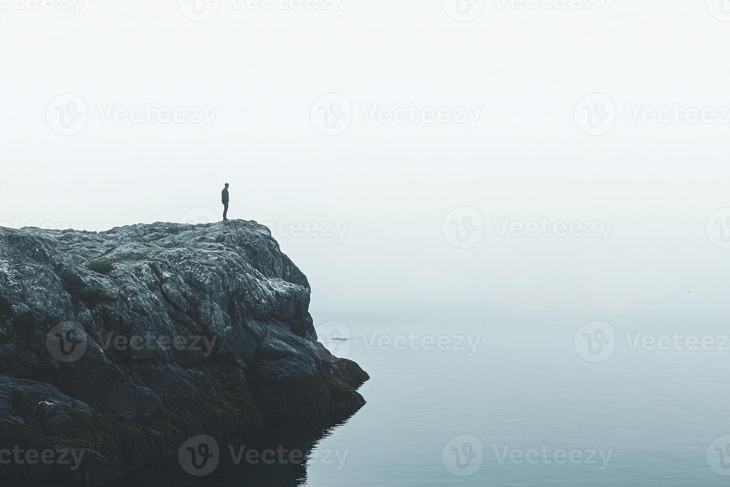 A solo hiker stands on a rocky cliff, absorbing the peaceful atmosphere of a Nordic fjord. Muted tones enhance the sense of tranquility and adventure in this breathtaking location photo