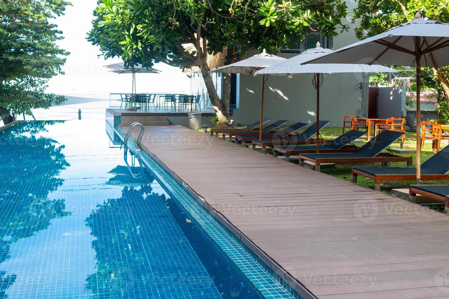 Swimming pool with many beach chairs photo